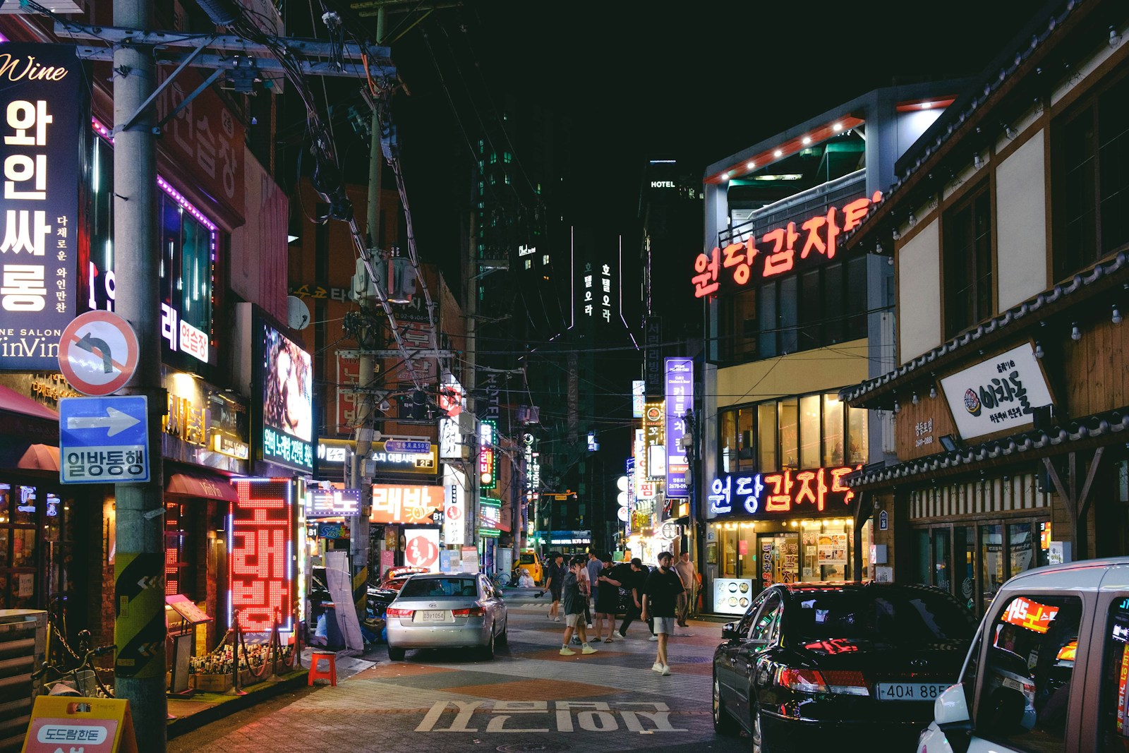 a busy city street at night with neon signs