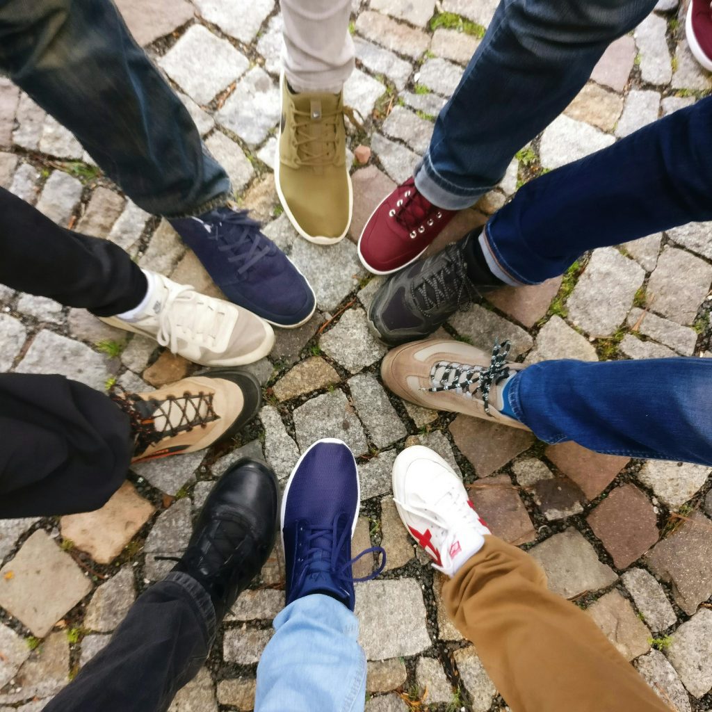 Technology and digital marketing Circle of sneakers on cobblestone pavement representing diversity and urban fashion.